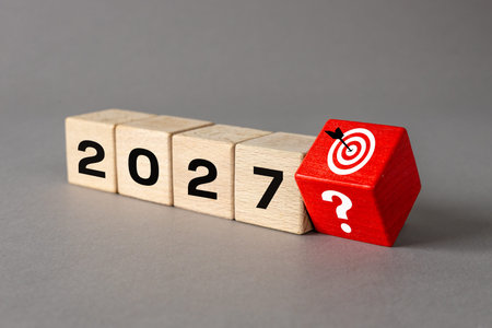 2027. Goals and unknowns for 2027. Question mark, target, and the date 2027 on wooden blocks....