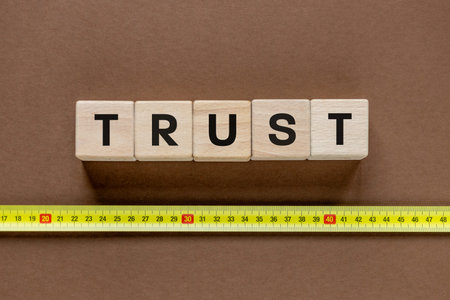 Measurement of trust. Business and financial concept. The word TRUST on a wooden block and a...