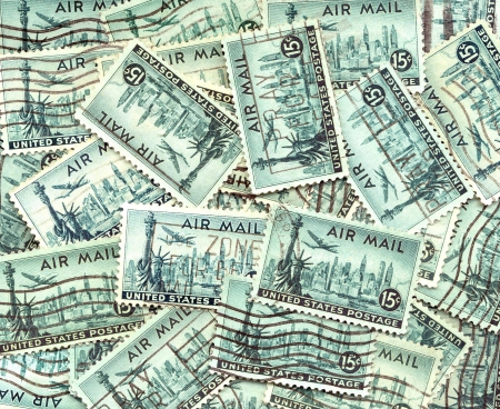 background of old used U S  air mail postage stamps with the Statue of Liberty in New York and airplane over the cityの写真素材