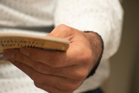 Close-up of a man's hand holding a book. Selective focus.