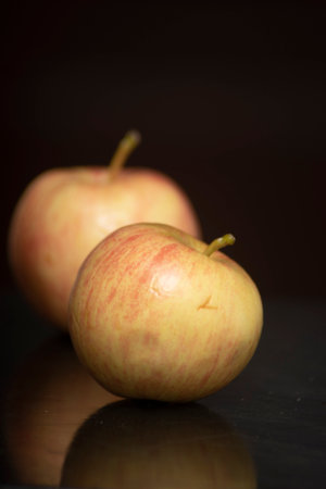 Two apples on a dark background. Shallow depth of field.