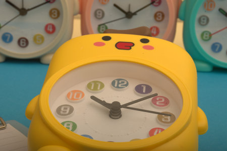 Yellow alarm clock on blue background. Time concept. Selective focus.