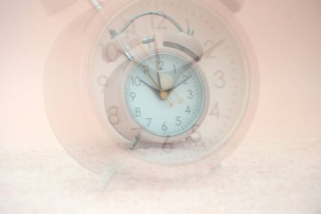 Retro alarm clock on the marble floor, vintage color tone.の写真素材