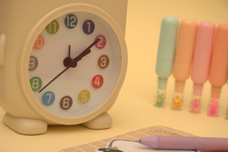 Alarm clock and markers on a yellow background. Time concept.のeditorial素材