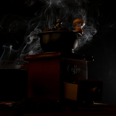 Coffee grinder with a cup of coffee on a black backgroundのeditorial素材