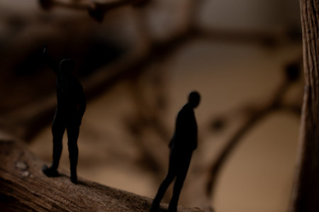 Miniature people: man and woman standing on a branch of tree.の写真素材