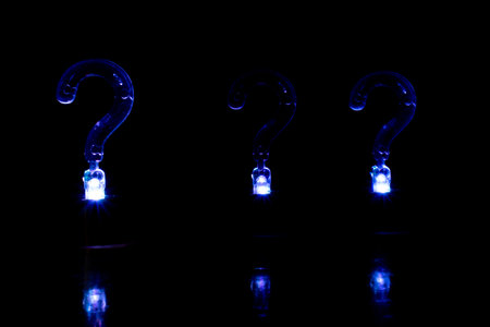 Question mark on a black background with blue light. Conceptual image.の写真素材