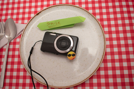 Vintage camera on a plate with a note on the table.