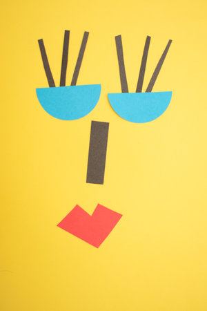Funny face made of paper on yellow background. Paper art conceptの写真素材