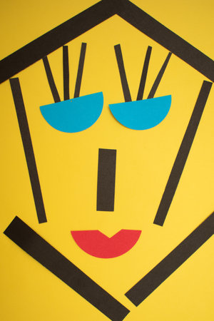 Funny face made of paper on yellow background. Minimal concept.の写真素材