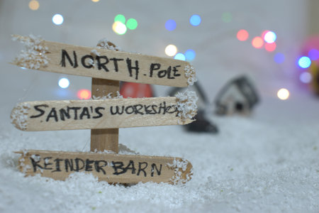 Wooden sign in the snow with christmas ornaments.の写真素材