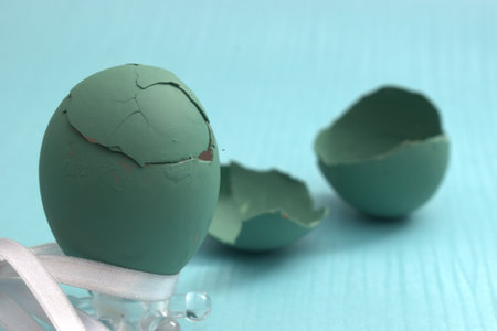 Broken eggshell on turquoise background with copy space.の写真素材