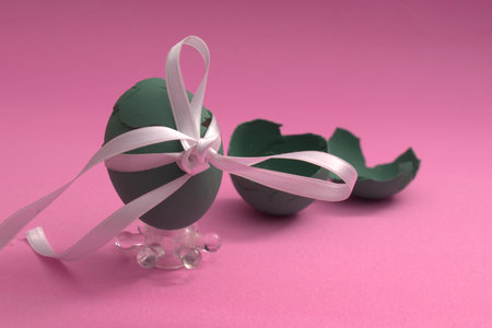 Easter egg with ribbon and bow on pink background, easter conceptの写真素材