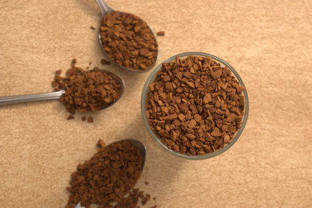 Instant coffee in a glass cup on a brown background, top viewの写真素材