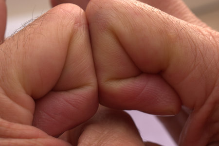 Man's hand holding a child's hand, close-up.の写真素材