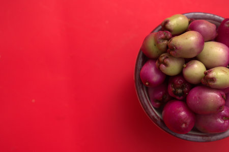 Fresh fruit in bowl on red background with copy space