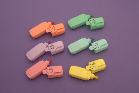 Colorful plastic objects on purple background. Top view.