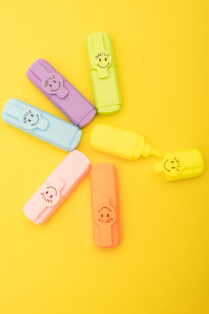 Colorful plastic markers isolated on a yellow background. Top view.の写真素材