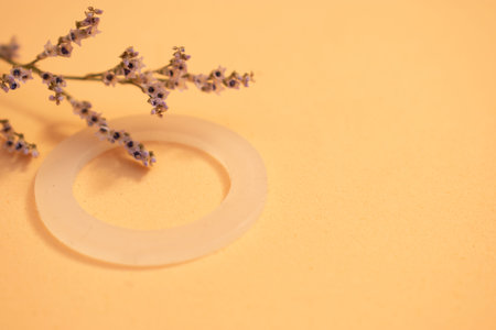 Wedding rings with lavender flowers on a yellow background.