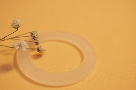 Wedding rings and gypsophila flowers on orange backgroundの写真素材