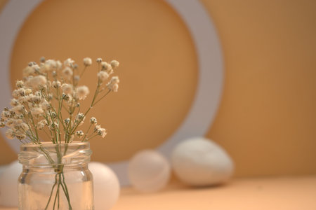 White gypsophila flowers in a jar on a beige backgroundの写真素材