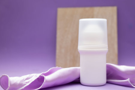 cosmetic bottle of deodorant on a purple background with a place for text