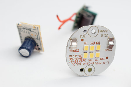 Electronic circuit board with electrical components on a white background. Selective focus.