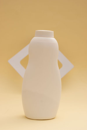 Plastic bottle for shampoo and conditioner on a yellow background.の写真素材
