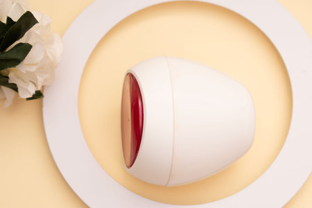 Coffee cup and flower on beige background. top view