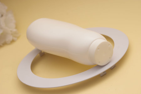 Plastic bottle of cosmetic cream on a stand on a yellow backgroundの写真素材