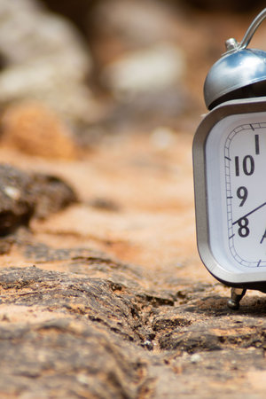 Alarm clock on the rock in the morning. Time concept.の写真素材