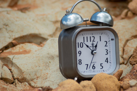 Alarm clock on stone background. Time concept. Selective focus.の写真素材