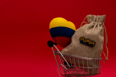 Shopping cart with a bag with the inscription Colombia and the flag of Colombia in the form of a heart on a red backgroundの写真素材