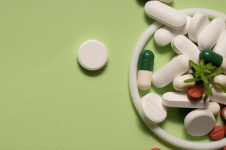 Pills and capsules on green background with copy space for text.の写真素材