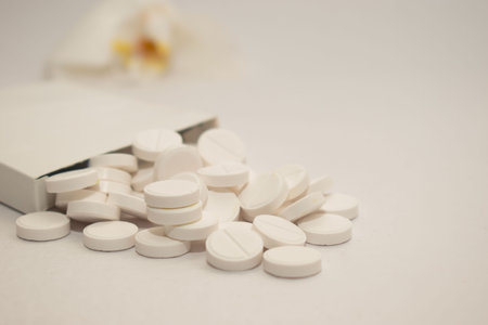 White pills on white background with copy space. Focus on foreground, soft bokeh.