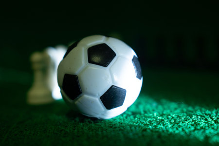 soccer ball and chess piece on green grass, shallow depth of fieldの写真素材