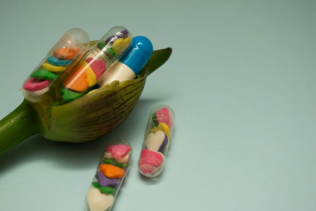 Colorful pills in capsules on a green background with copy space.の写真素材