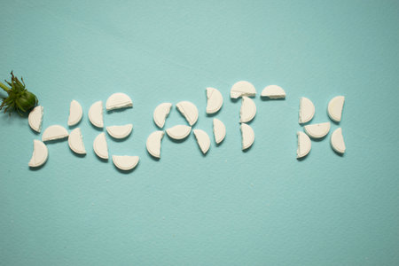 Alphabet made from white pills on blue background. Selective focus. Toned.