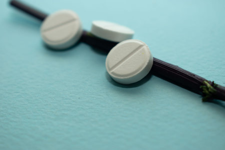 Close up of white medical pills against blue background. Focus on foreground.