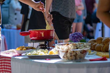 Close up detail shot of person's arm stirring a traditional tasty delicious pot of hot melted liquid...
