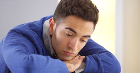 Moody Mexican man resting on deskの写真素材