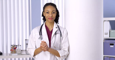 Friendly African woman doctor standing in officeの写真素材