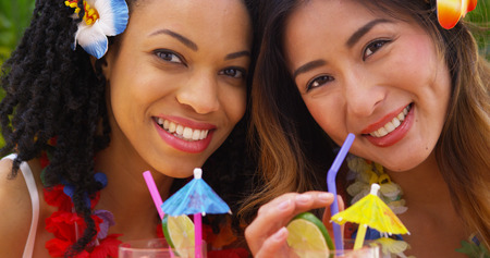 Close up of Beautiful African American and Asian women on vacation togetherの写真素材