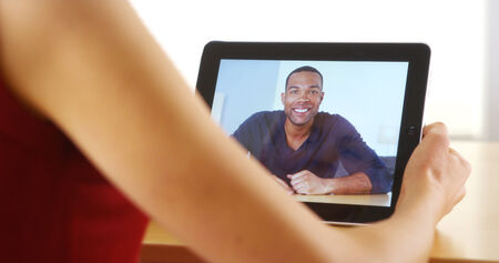 Closeup of happy black man talking on tablet