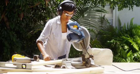Black woman doing home improvement measuring wood