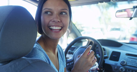 Happy young woman waiting in her car