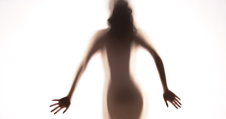 Attractive Mexican woman standing behind curtainの写真素材