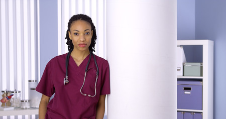 Black woman nurse standing in officeの写真素材