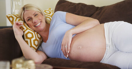 Beautiful pregnant woman lying on couch
