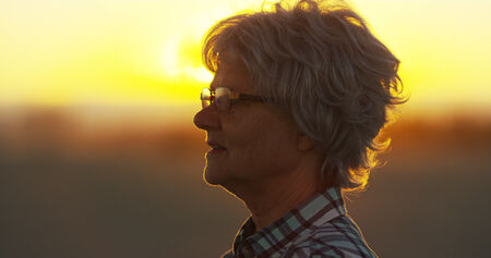 Senior woman standing on beachの写真素材